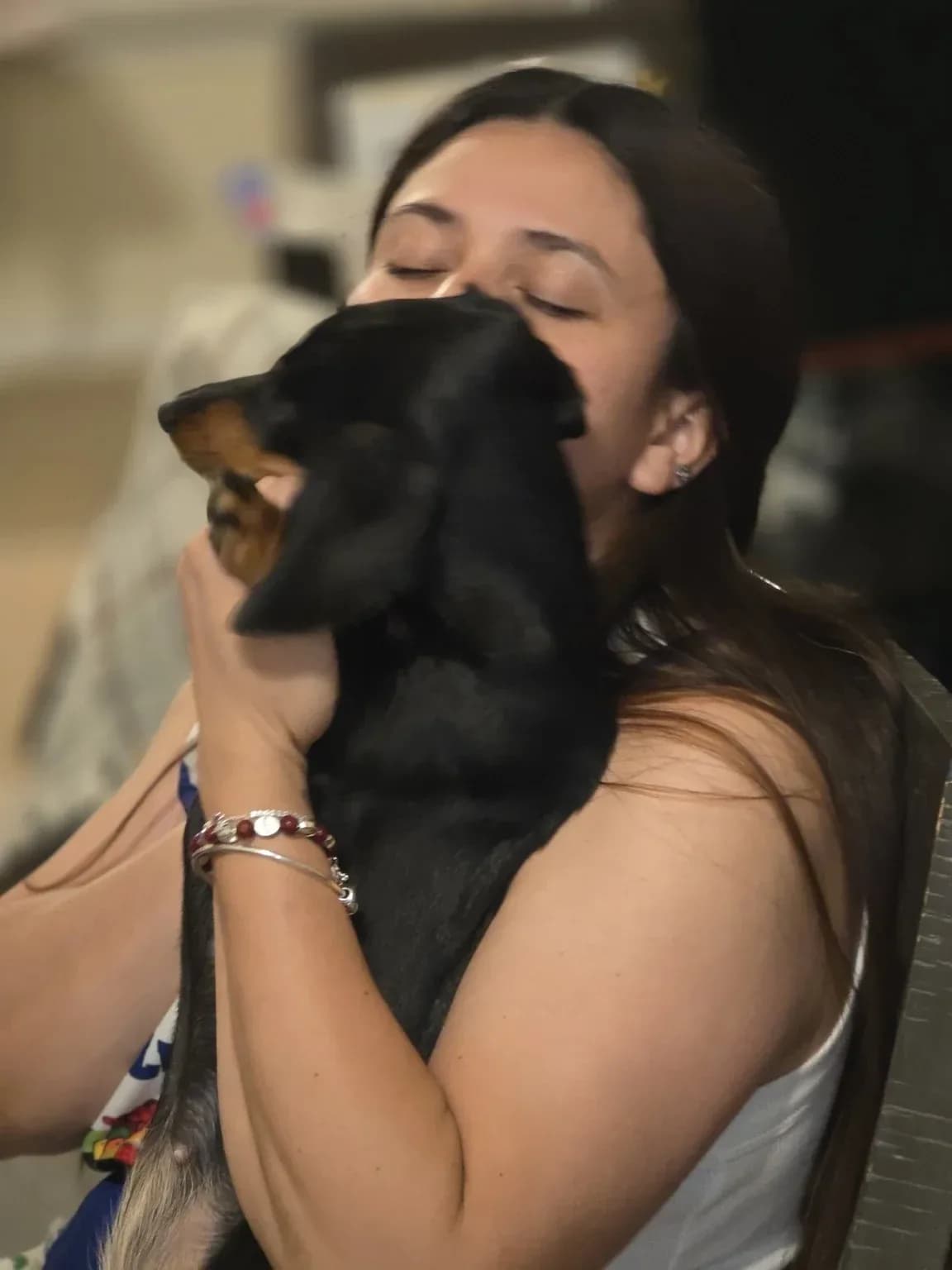 A woman with her eyes closed holding Luna up against her cheek